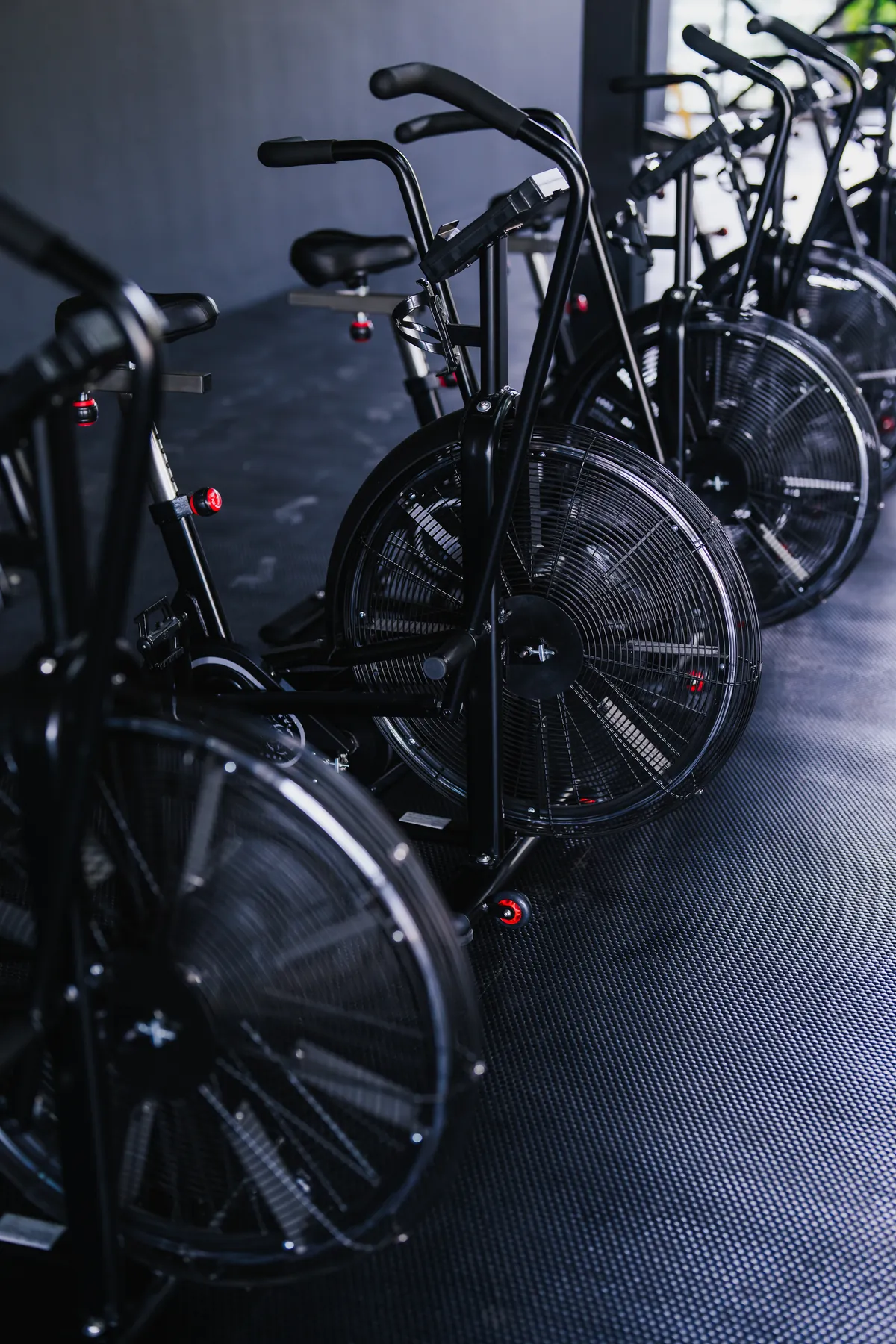 A row of air bikes ready on the EMPOWER fitness floor