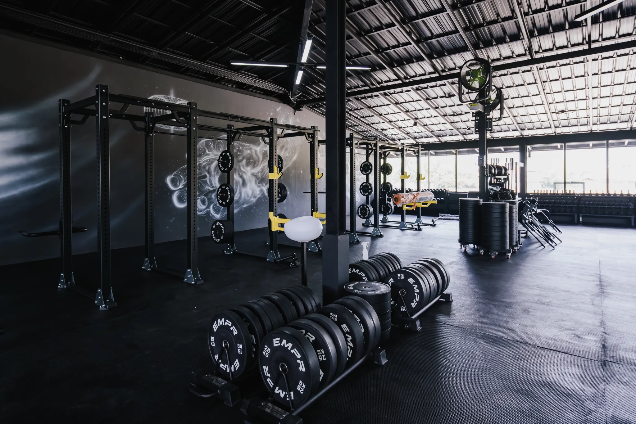 Power racks, weight plates and open training space at EMPOWER Gym Kamala