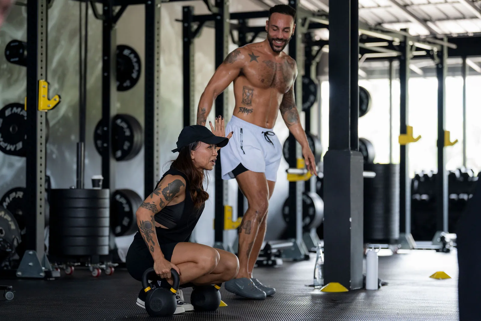 EMPOWER coach encouraging a smiling member during kettlebell training