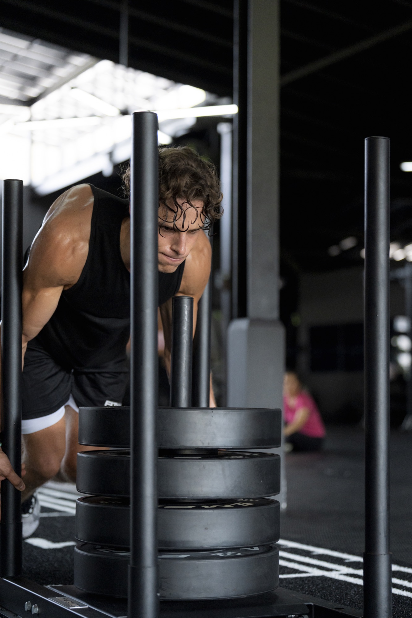 Athlete pushing a weighted sled during HYROX training