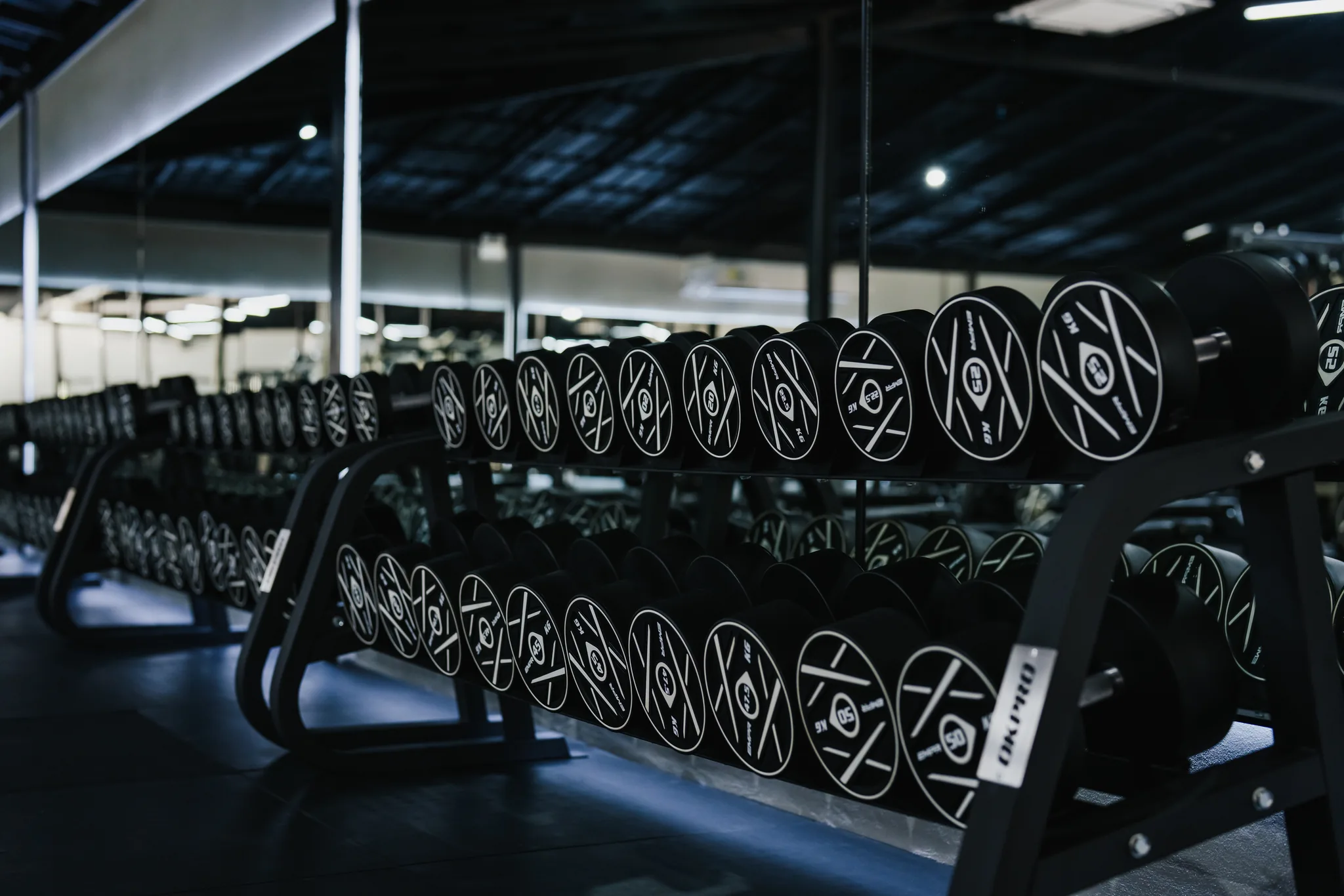 Full dumbbell wall reflected in the mirrors at EMPOWER Gym Kamala