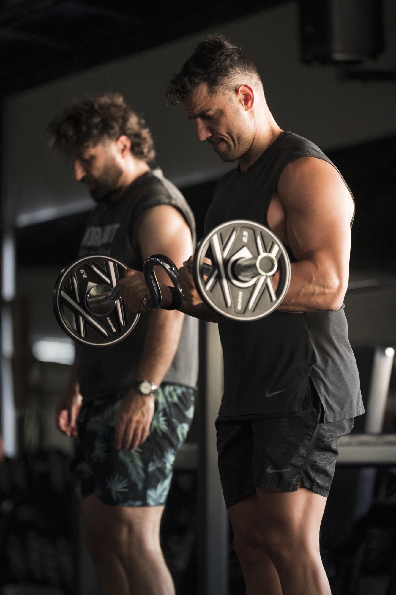 Athletes training with fixed barbells