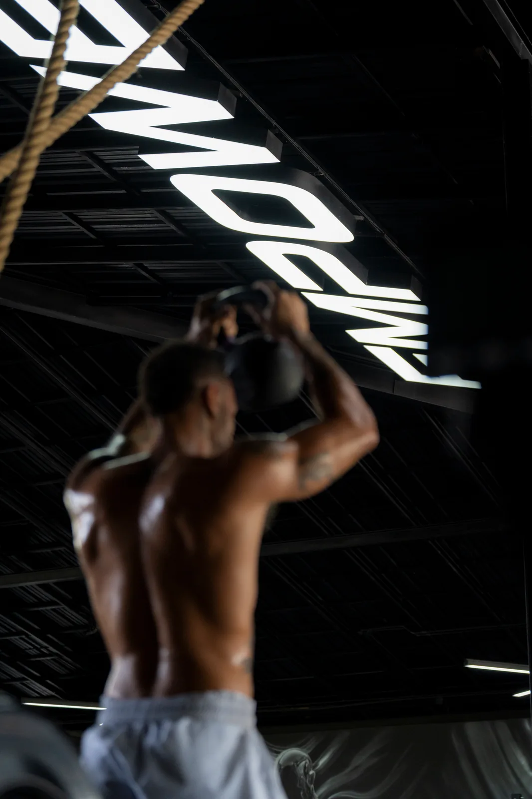 Close-up training moment beneath the EMPOWER gym sign