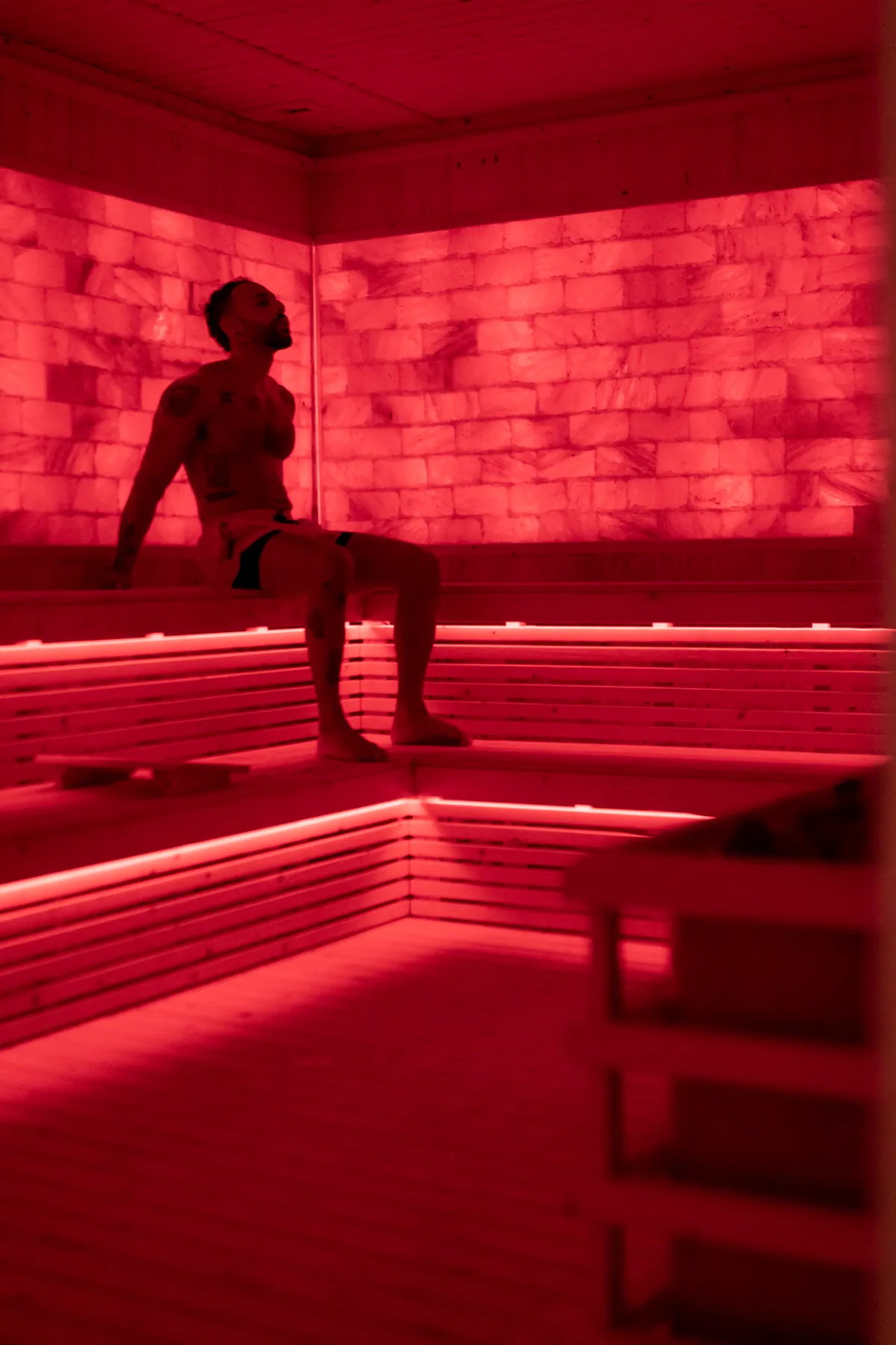 Guest resting inside the red-light Himalayan salt sauna