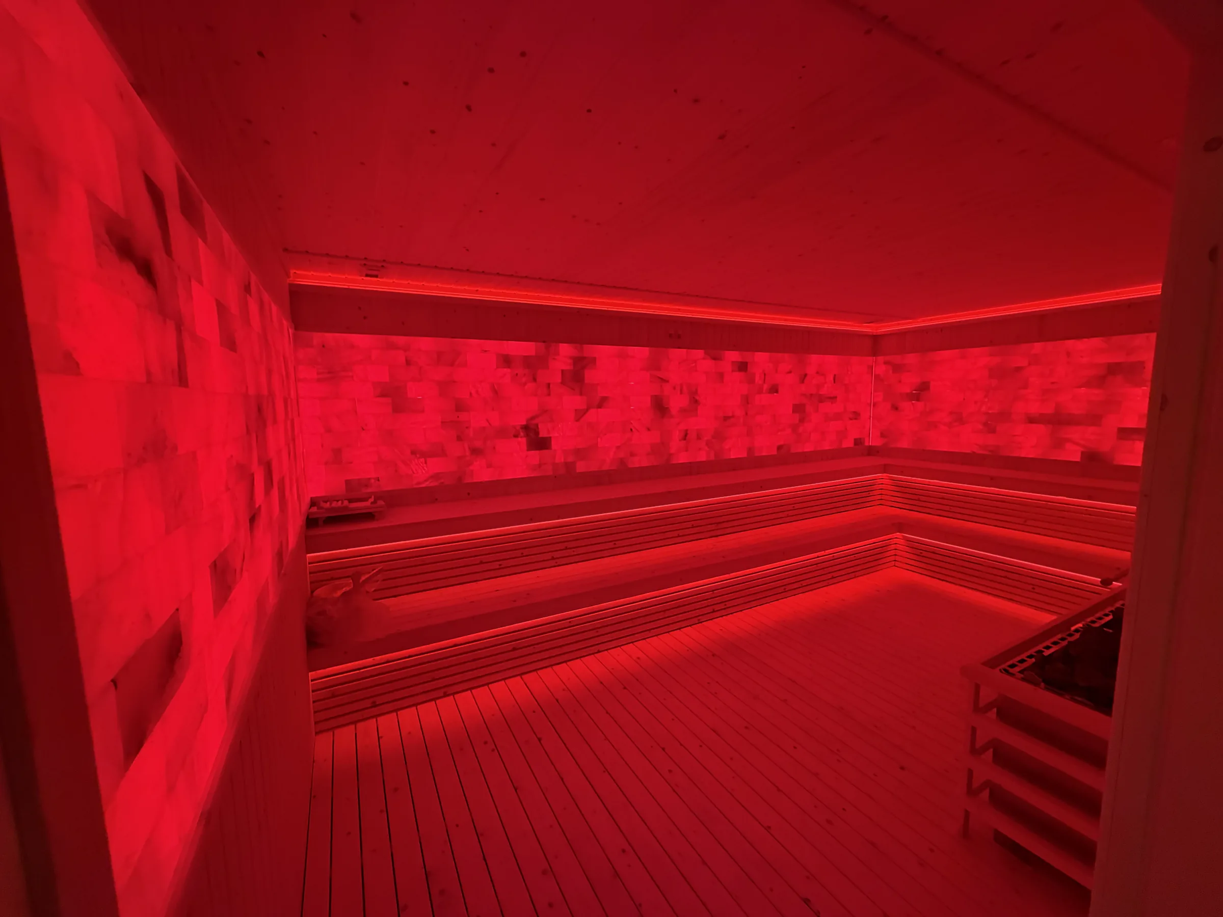 Guest relaxing in the red-light Himalayan salt sauna at EMPOWER