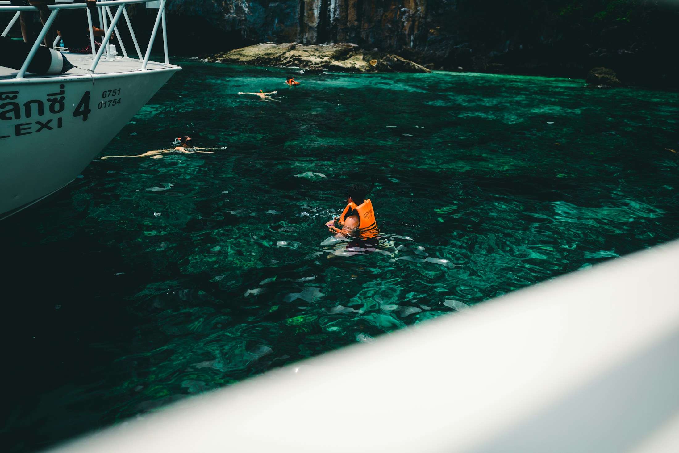 Travellers snorkelling in clear water off Phuket