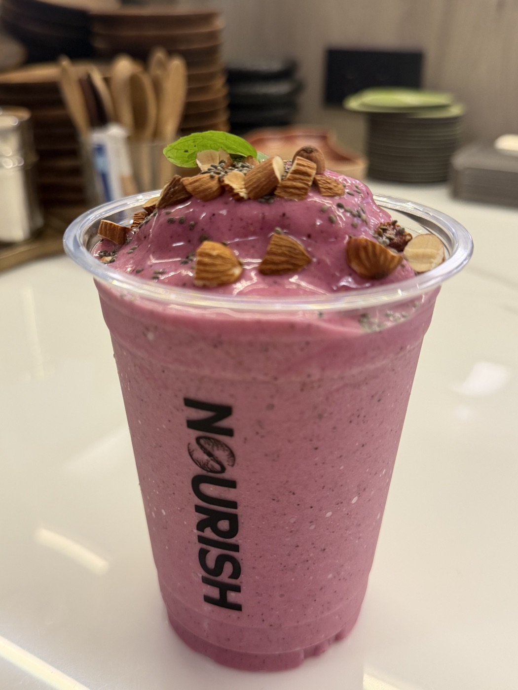 Branded berry smoothie topped with almonds at NOURISH