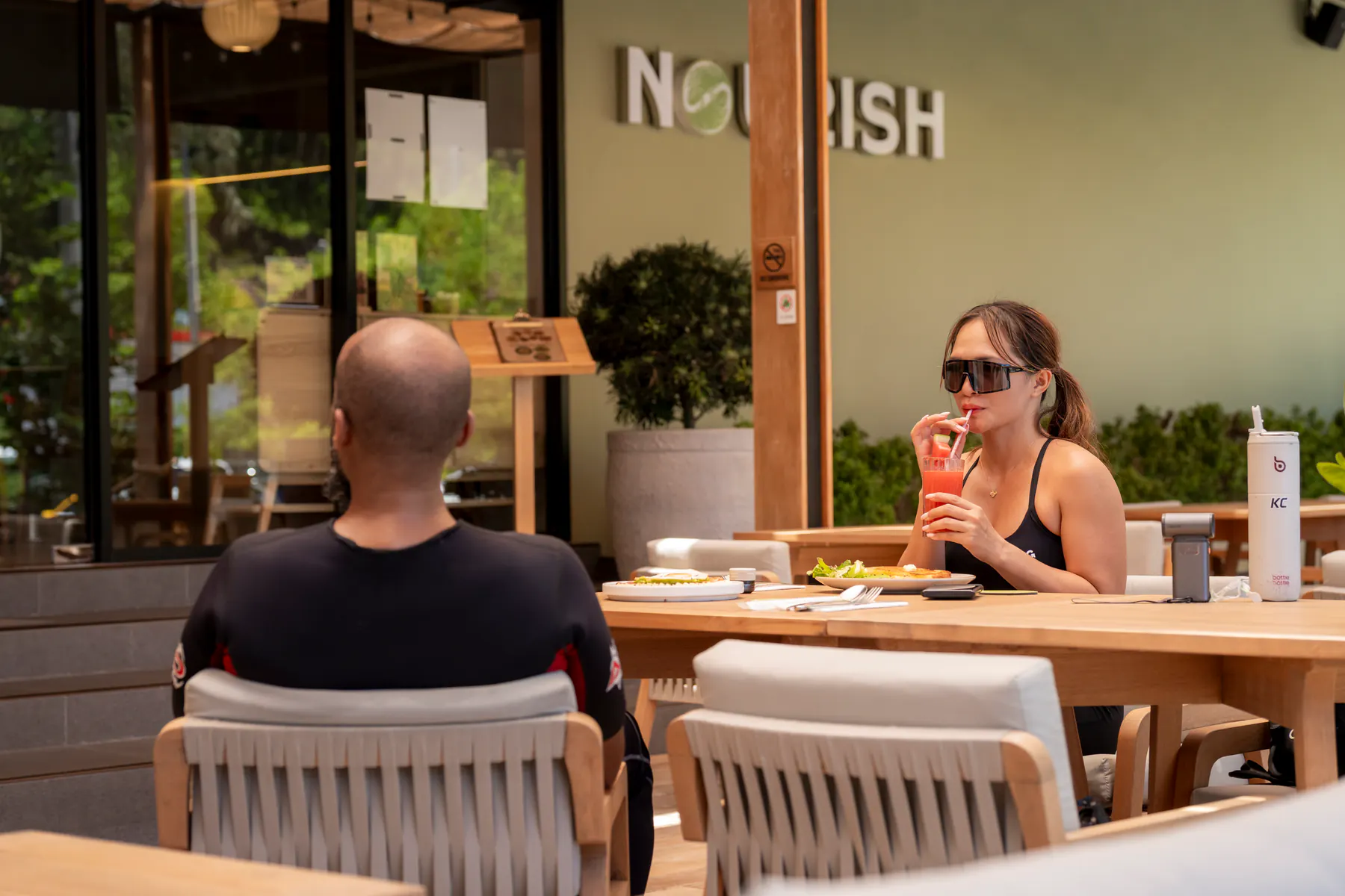 Guests dining together outside NOURISH restaurant in Kamala, Phuket